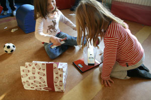 die beiden Mädchen legen eine Wasserwaage auf den Haushaltsmessbecher